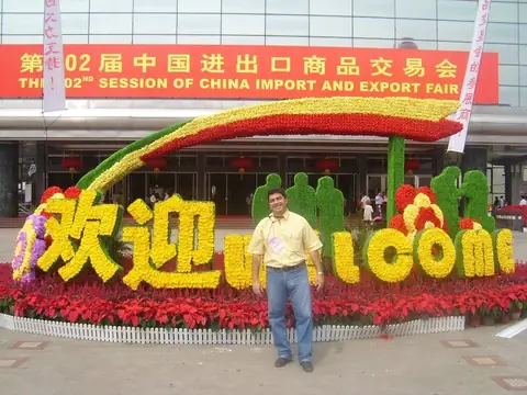 Fernando Reis na entrada da Feira de Importação e Exportação da China, a Feira de Cantão, ao lado da placa de boas-vindas